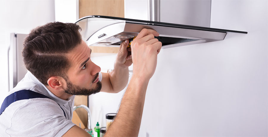 An Electrician installing an exhaust fan